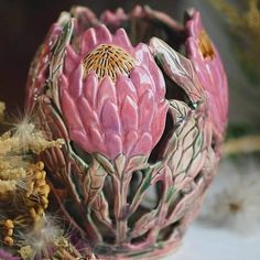 a pink flower sitting on top of a table next to other flowers