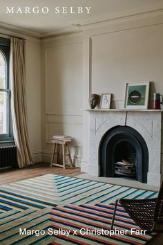 a living room with a fire place and a rug in front of the fireplace that reads margo selby