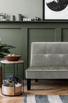 a grey couch sitting next to a table and potted plant in a living room