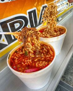 two bowls of ramen with chopsticks sticking out of them