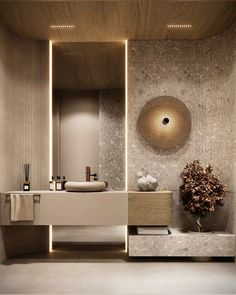 a bathroom with a sink, mirror and vase on the counter top in front of it