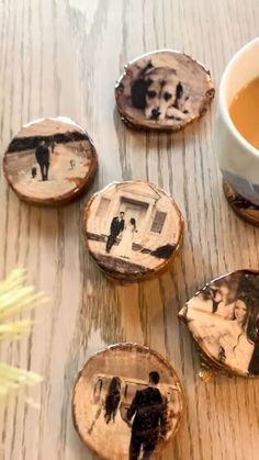 four pieces of wood with pictures on them and a cup of tea next to it