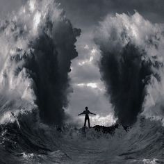 a man standing on top of a surfboard in the middle of a large wave