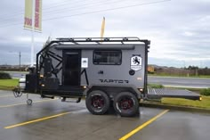 an off - road camper trailer parked in a parking lot on a cloudy day