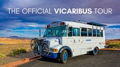 a white bus parked on the side of a road with a bike rack attached to it's front