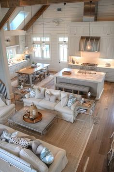 a living room filled with furniture and a kitchen in the backround behind it