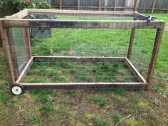 a small cage with wheels on the grass