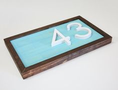 a wooden sign with white numbers on it