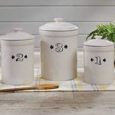 three white canisters sitting on top of a table