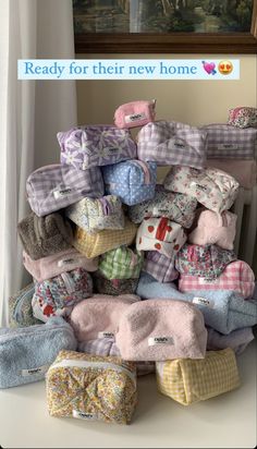 a pile of baby blankets sitting on top of a white table next to a window