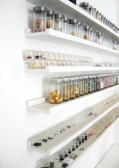 the shelves are filled with many different types of jars and containers, all lined up against each other