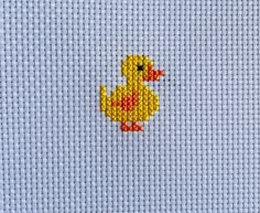 a small yellow ducky on a light blue background is featured in this cross stitch pattern