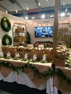 the table is set up with candles and other items for sale in front of a television