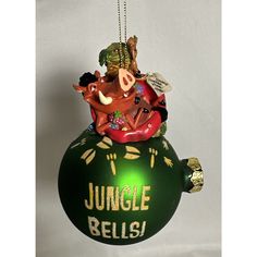 a green ornament with some animals hanging from it's side and the words jungle bells written on it