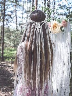 the back of a woman's head with long hair and flowers in her hair