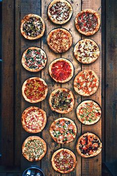 many different types of pizzas on wooden boards