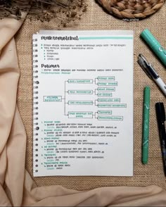 a notepad sitting on top of a table next to some pens