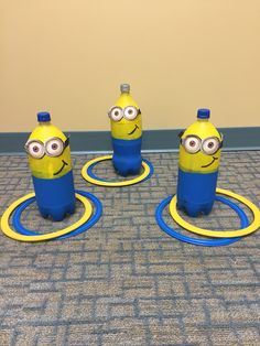 three yellow and blue minion bottles sitting on the floor