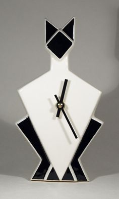 a clock with black and white designs on it's face in the shape of a man