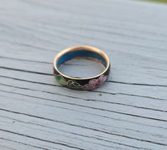 This is a vintage cloisonne ring. It is black and has a gorgeous pink flowers & green leaf design. Made in the 1970s. Size: 8 Band width: 5mm Condition: Good Maker's Mark: None This model ring is retired and is no longer in production. All jewelry items come in a gift box. #VS16 Cherry Blossom Ring, Christmas Ring, Ring Inspo, Fun Jewelry, Flowers Green, Ring Black, Maker's Mark, Green Leaf, Vintage Gifts