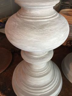 a white vase sitting on top of a wooden table