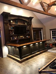 an unfinished bar in the middle of a house being built with wood beams and lighting