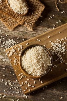 white rice in a wooden bowl on a cutting board next to some burlies