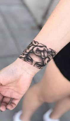 a woman's hand with a tattoo on it and an image of her face