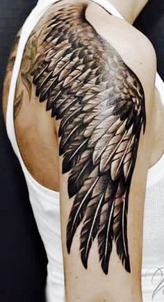 a woman with a tattoo on her arm and wings painted on it's shoulder