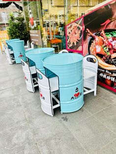 several blue and white buckets are lined up on the side of a building in front of a restaurant