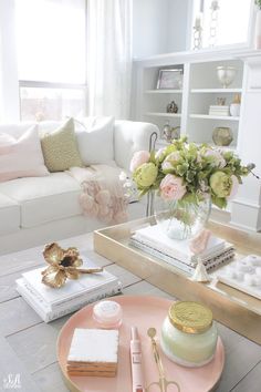 a living room filled with furniture and flowers in a vase on top of a table