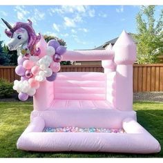 an inflatable unicorn bouncer with balloons