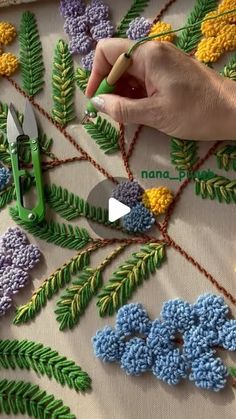 someone is working with crochet on some flowers and leaves that are being worked on