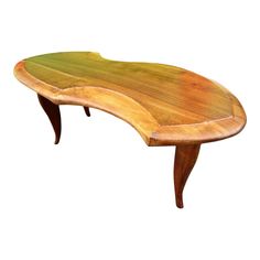 an oval wooden table with curved legs and wood grain on the top, sitting in front of a white background