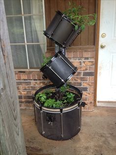 an old drum is turned into a planter with plants growing out of the top