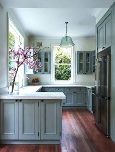 a kitchen with wooden floors and gray cabinets