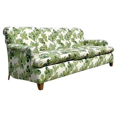 a green and white couch with leaves on it