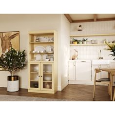 a kitchen with white walls and wooden floors, an open bookcase is next to a dining room table