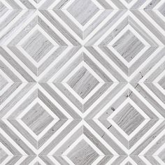 a white and gray tiled wall with different patterns on the tile, as well as lines