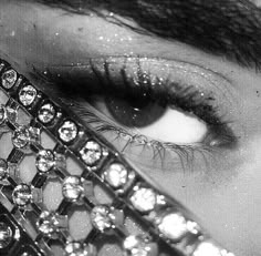 a woman's eye is covered with jewels