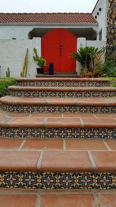 the steps lead up to a red door in front of a house