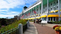 a large white building with yellow umbrellas on the sides and flowers in front of it