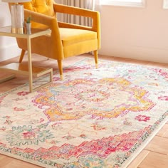 a yellow chair sitting on top of a wooden floor next to a white and red rug