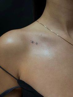 a woman's chest with two small stars on the left side of her breast