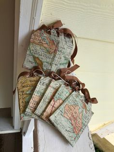 four pieces of luggage sitting on top of a white doorknob with brown ribbon