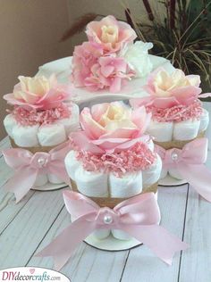 a cake made to look like baby diapers with pink flowers on top and bows around the edges