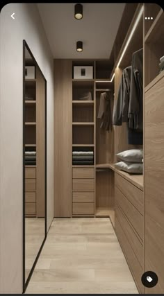 an empty walk in closet with wooden cabinets