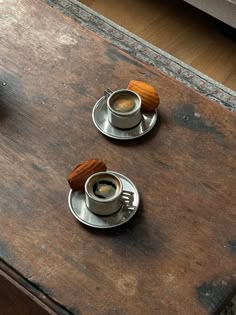 two cups of coffee on a wooden table