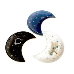 three pieces of glass sitting next to each other on a white surface with stars and moon designs