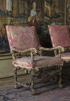 two chairs sitting next to each other in front of a painting